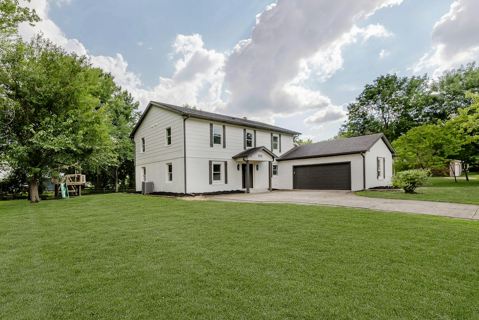 Maison à étages blanche avec garage, façade avant